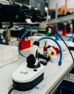 An electric vehicle charger sits on a workbench.